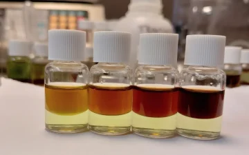 Four PRO Test for Cocaine Quantity reference vials, top layers from orange at 25% cocaine to near black at 100%