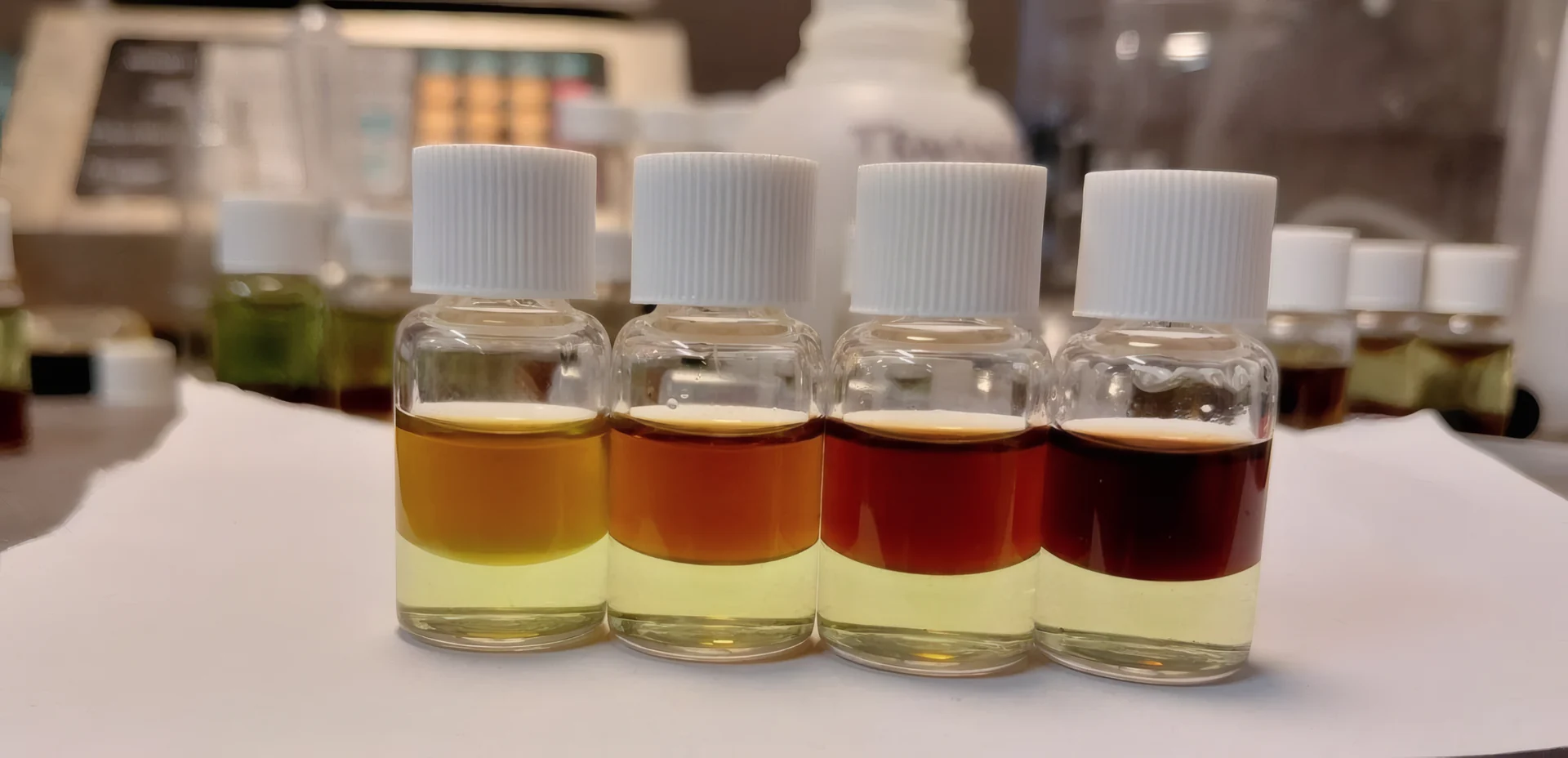 Four PRO Test for Cocaine Quantity reference vials, top layers from orange at 25% cocaine to near black at 100%